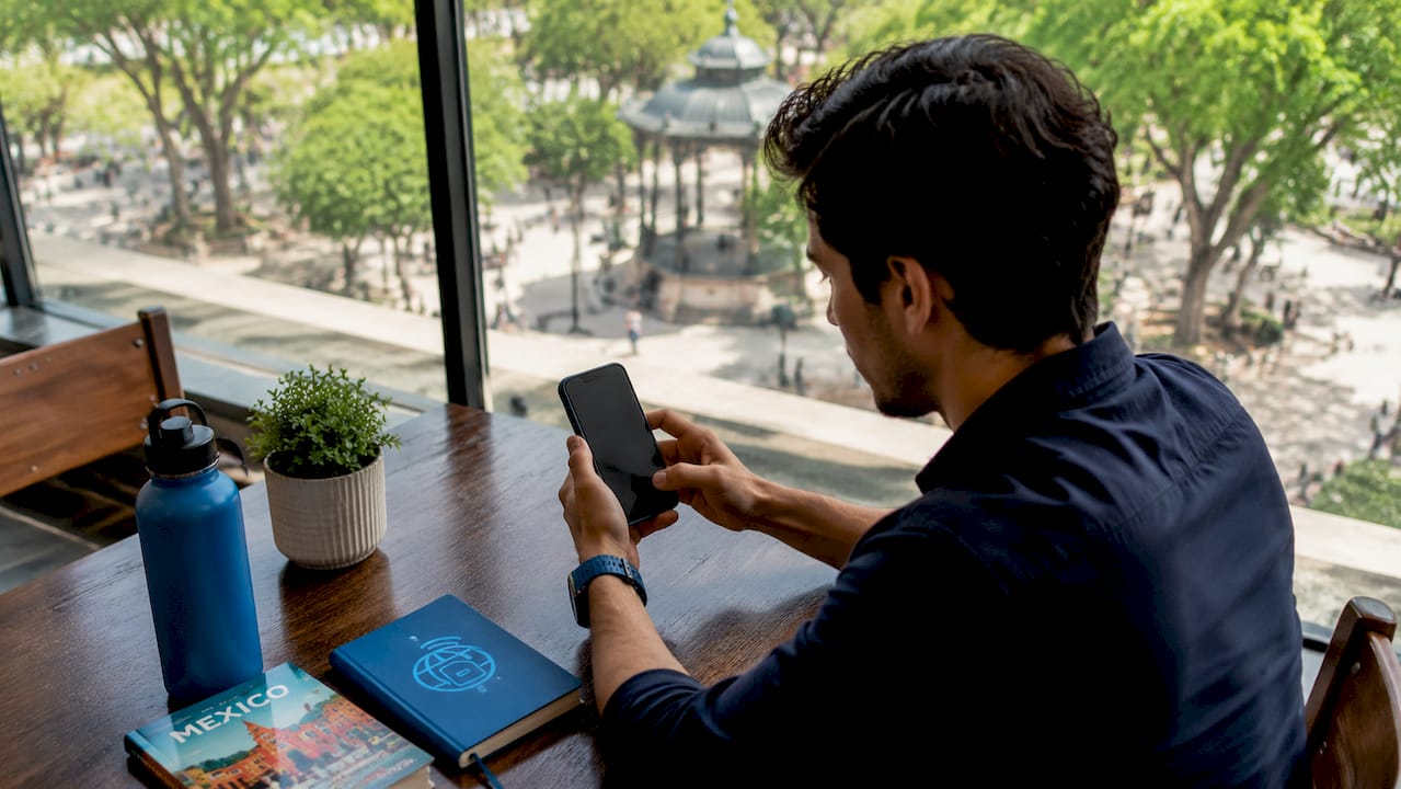 Person activating eSIM on smartphone at home desk