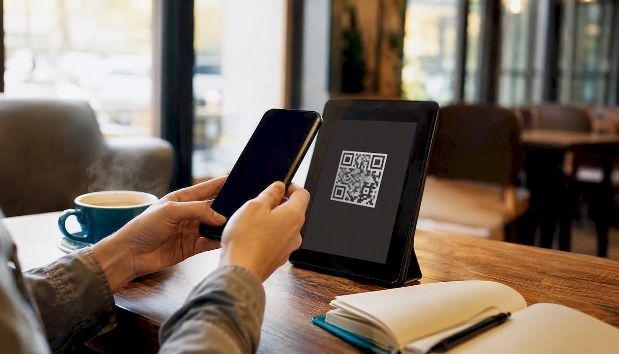 Hands holding phone scanning QR code
