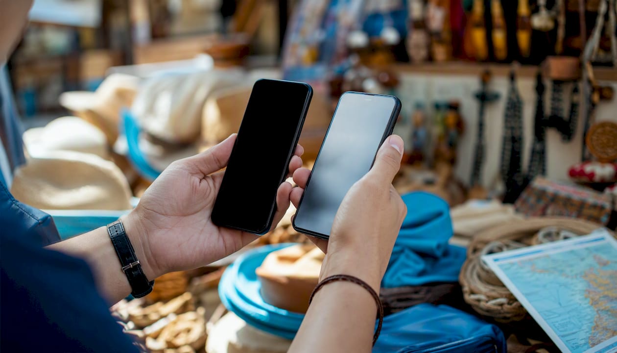Hands holding smartphones for eSIM transfer