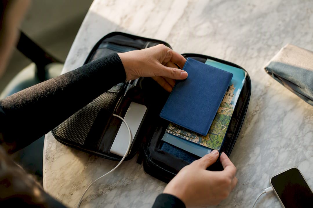 Hands packing travel essentials with phone off
