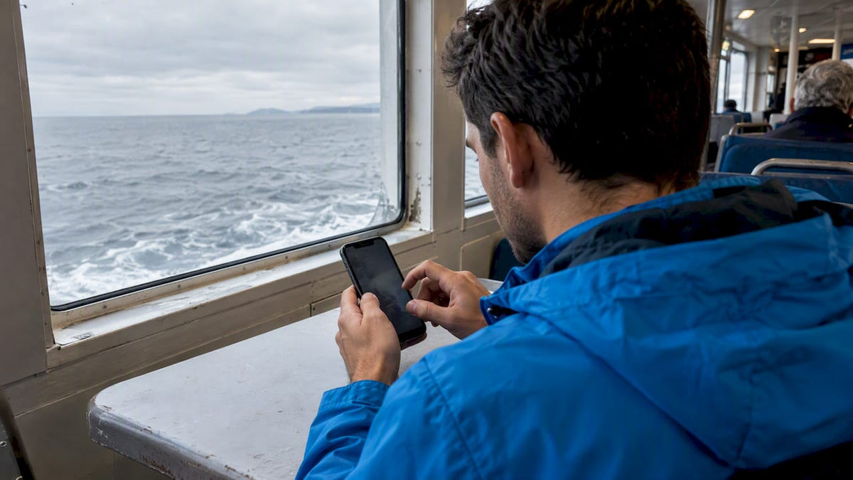 Traveler adjusting mobile network settings aboard a ferry